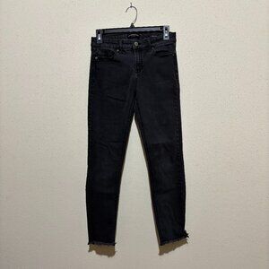 Black, mid-rise skinny jeans with frayed bottoms